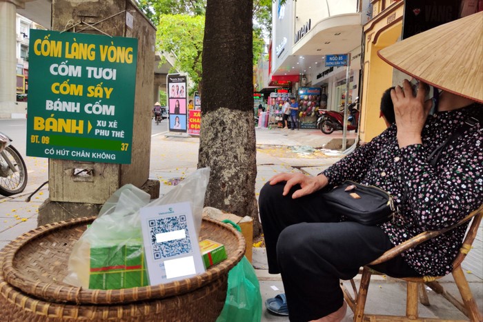 A green sticky rice vendor's stall with a QR code